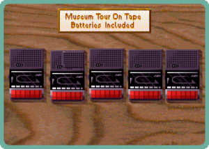 Screenshot from Museum Madness, showing several tape cassette players on the table. A placard reads "Museum tour on tape, batteries included."